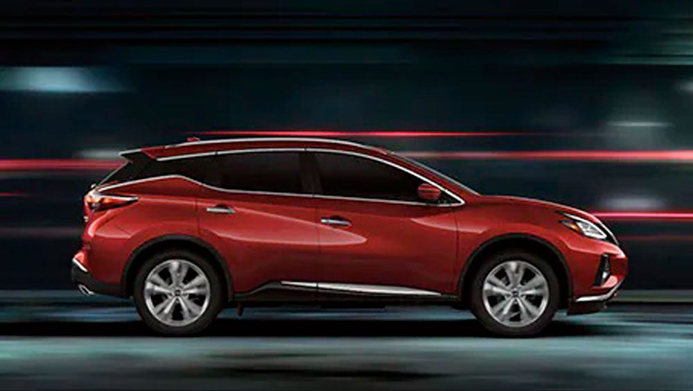 2023 Nissan Murano shown in profile driving down a street at night illustrating performance. | Crossroads Nissan Wake Forest in Wake Forest NC